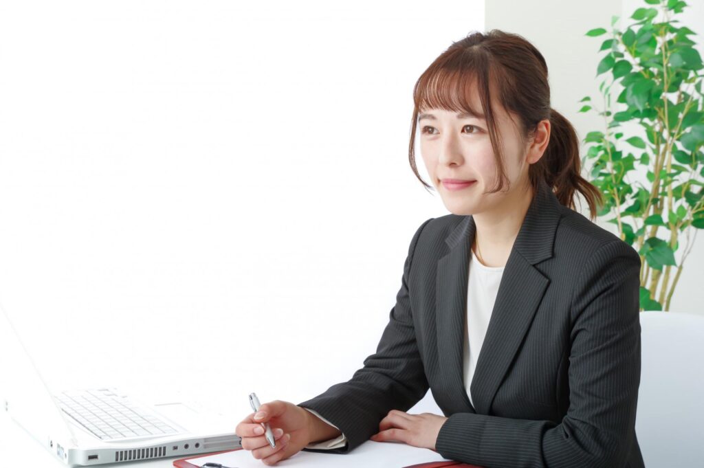 書類に記入するスーツ姿の女性の写真