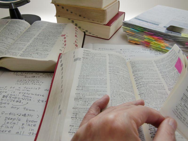 英語学習で辞書やノートを使って調べものをしている画像